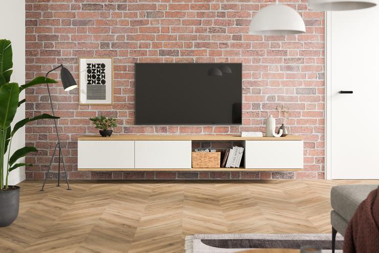 Maßangefertigtes Hängeboard in Weiß, minimalistisch gestaltet, unter einem Wandfernseher, vor einer roten Backsteinwand, ergänzt durch Pflanzen und Bücher.